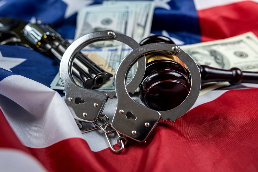 gavel and handcuffs and money and gun on the background of the american flag of the usa