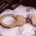 gun and police handcuffs on fingerprints