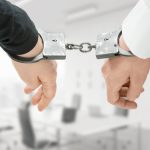 hands of two men fixed in handcuffs